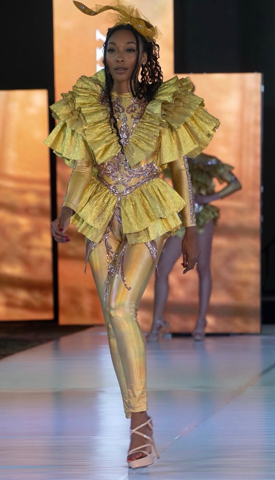 Amari Kelley in a gold ruffled couture look on the runway